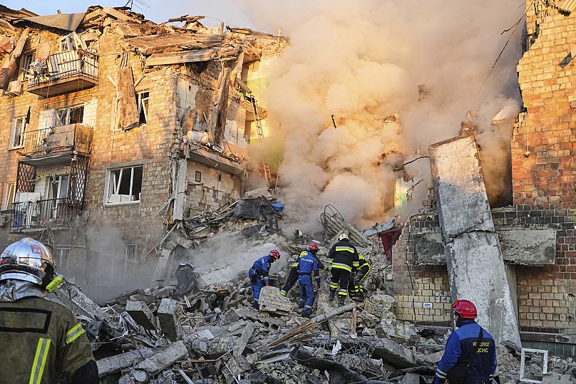 Firefighters work on the site of a burning building after a Russian attack in Kyiv, Ukraine, early Thursday, Aug. 28, 2025.