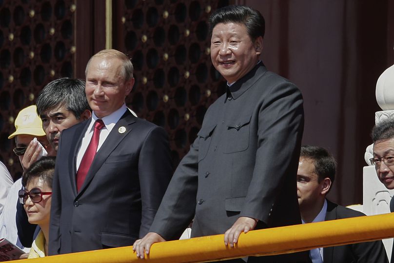 Председатель КНР Си Цзиньпин и президент России Владимир Путин наблюдают за парадом, посвященным 70-летию победы во Второй мировой войне, у ворот Тяньаньмэнь в