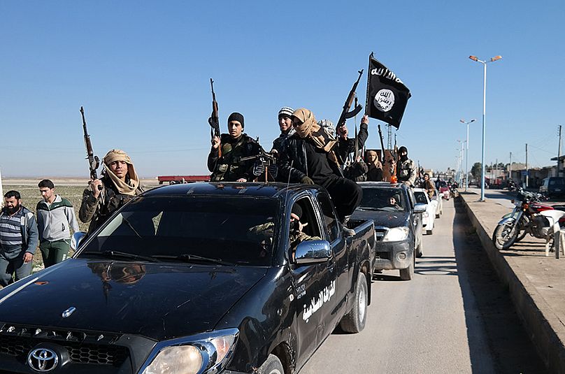 Islamic State militants pass by a convoy in Tel Abyad, northeast Syria, 4 May 2015