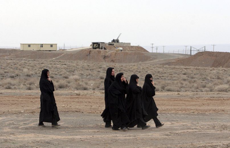 صورة أرشيفية - نساء إيرانيات يمررن أمام مدفع مضاد للطائرات، في ختام مسيرة لدعم البرامج النووية الإيرانية، أمام منشأة نطنز لتخصيب اليورانيوم،