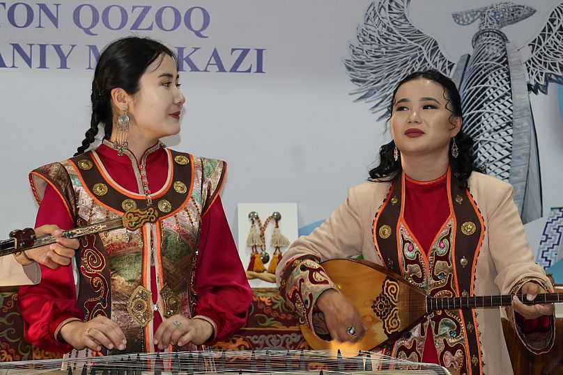 Kazakh musicians present traditional instruments and attire at a cultural exhibition in Tashkent.