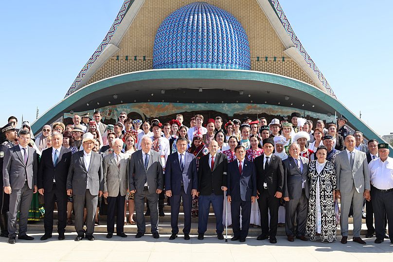 Representatives of various ethnic groups and dignitaries gather in front of the Independence Monument in New Uzbekistan Park
