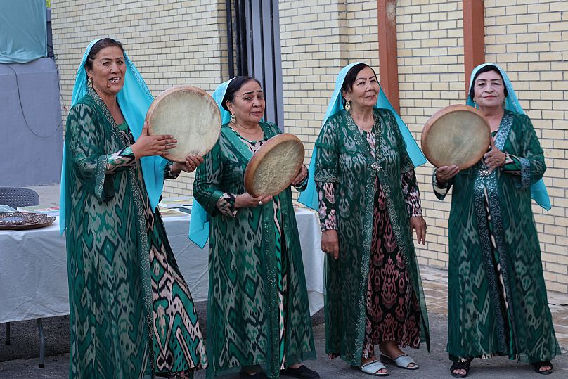 A group of Uzbek women perform with traditional doira drums during a cultural event