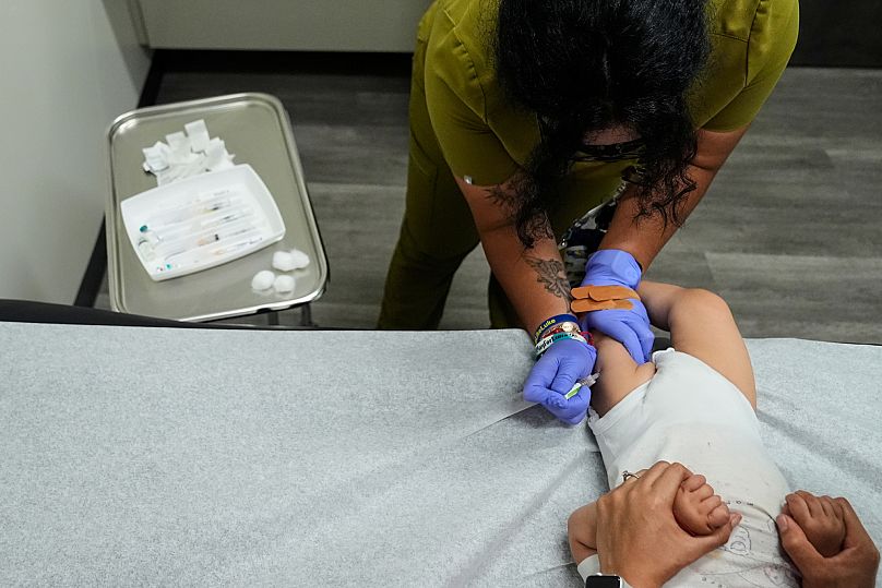 Une assistante médicale administre une série de vaccins à un garçon de 16 mois.