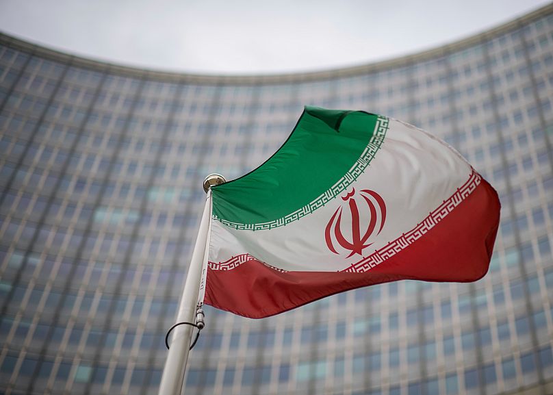 A national flag of Iran in front of the building of the International Atomic Energy Agency in Vienna, 17 December, 2021