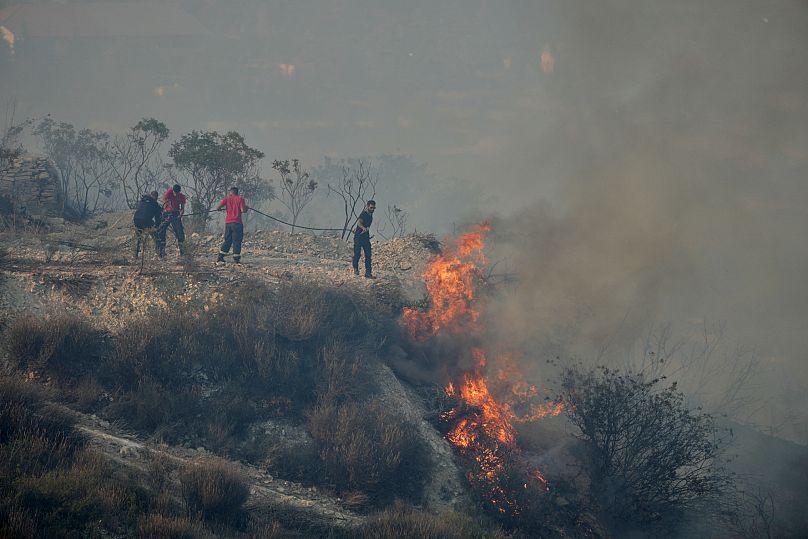 Residents gather to battle the fire at Omodos village, 24 July 2025