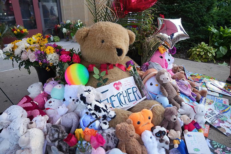 Items including dolls are placed at a memorial at Annunciation Catholic Church after Wednesday's school shooting, Thursday, Aug. 28, 2025, in Minneapolis.