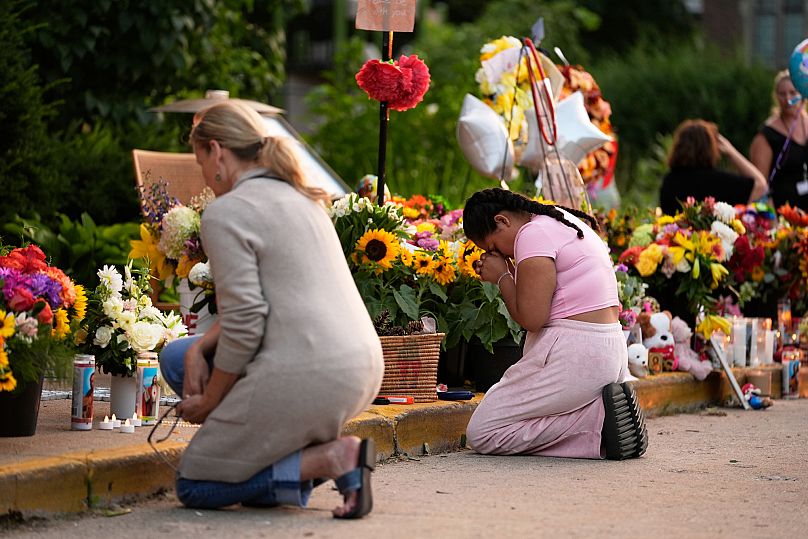People pray at a memorial at Annunciation Catholic Church after Wednesday's school shooting, Thursday, Aug. 28, 2025, in Minneapolis.