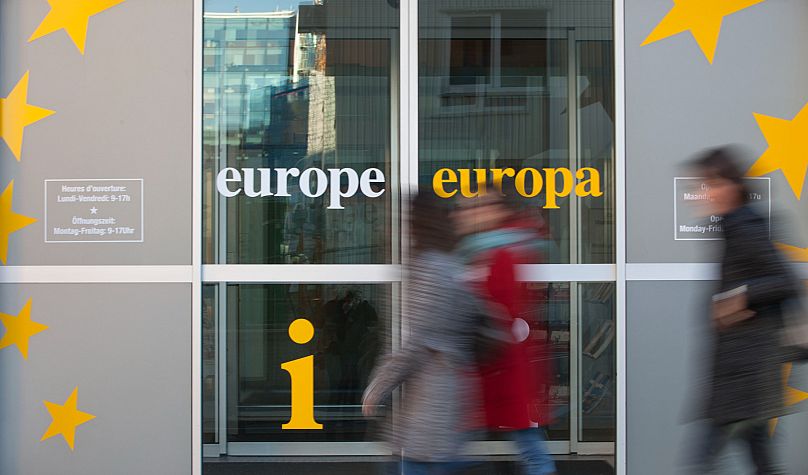 People walk in front of an information office outside of an EU summit in Brussels. November 2012.
