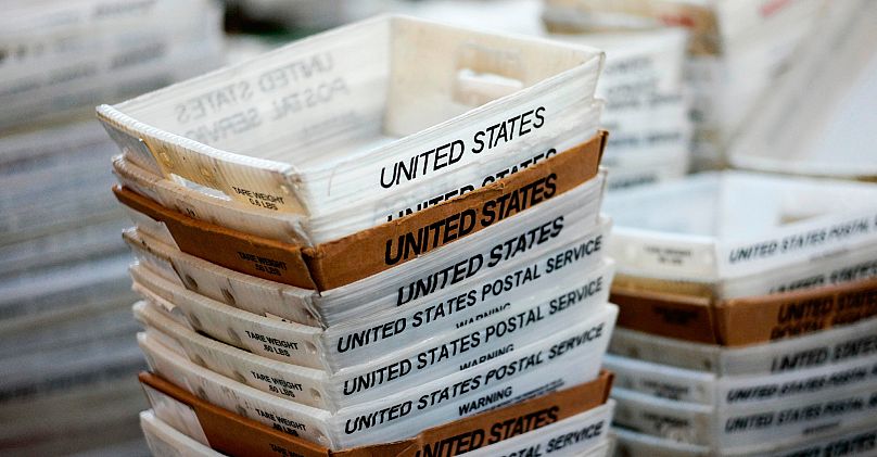 FILE- In this Dec. 14, 2017, file photo, boxes for sorted mail are stacked at the main post office in Omaha, Neb.
