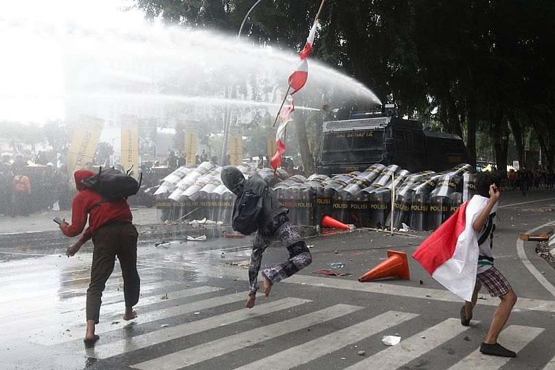 People throw rocks at the police during a protest in Medan, 29 August, 2025