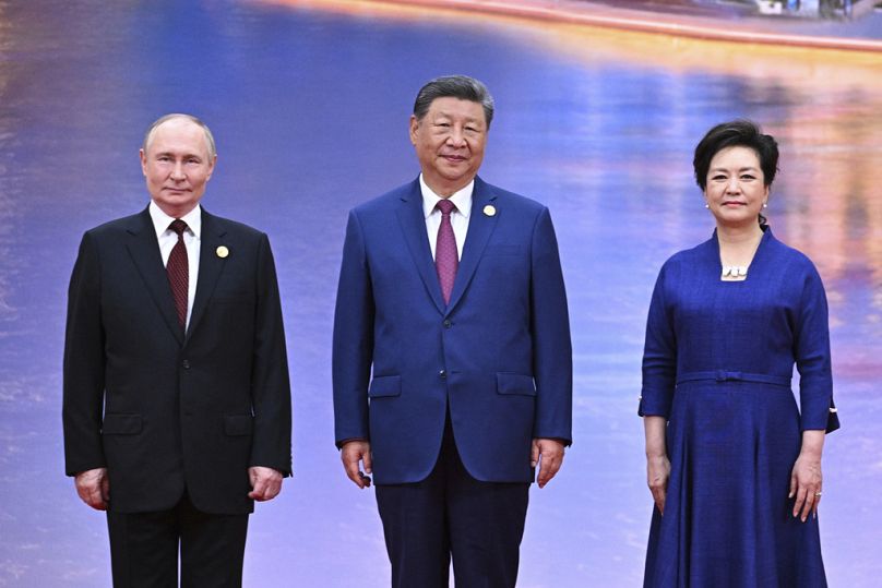O Presidente russo Vladimir Putin, à esquerda, o Presidente chinês Xi Jinping, ao centro, e a sua esposa Peng Liyuan, posam para uma fotografia