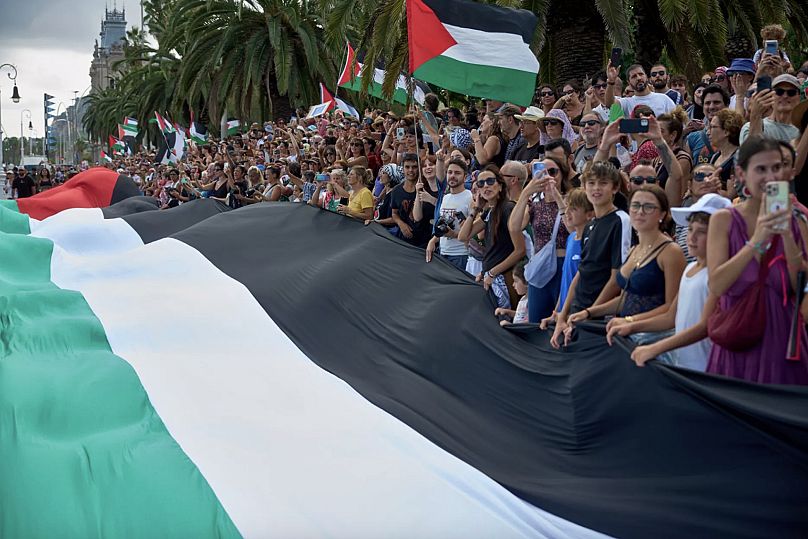 İspanya'nın Barselona kentinde Gazze'ye giden sivil bir filoya katılmak üzere yola çıkan aktivistlere veda ederken Filistin bayrakları taşıyanlar, 31 Ağustos 2025.