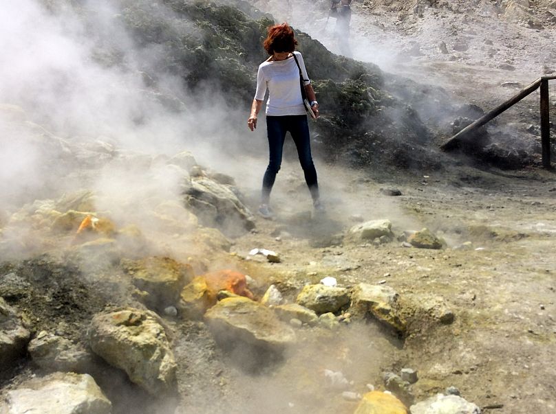 photo prise en 2016, une femme observe attentivement une fumerolle fumante au fond du cratère de la Solfatara, dans les Champs Phlégréens près de Naples, en Italie. 