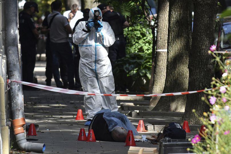 A forensic expert photographs a body of a former Ukrainian parliament speaker Andriy Paroubiy, in Lviv, Ukraine, Saturday, Aug. 30, 2025.