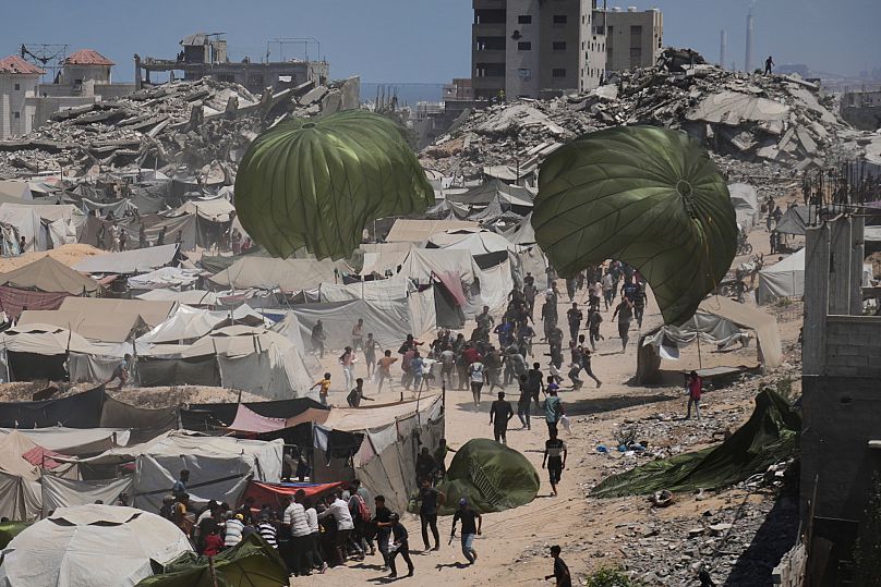 Les Palestiniens se précipitent pour récupérer l'aide humanitaire larguée par parachute dans la ville de Gaza, le 7 août 2025