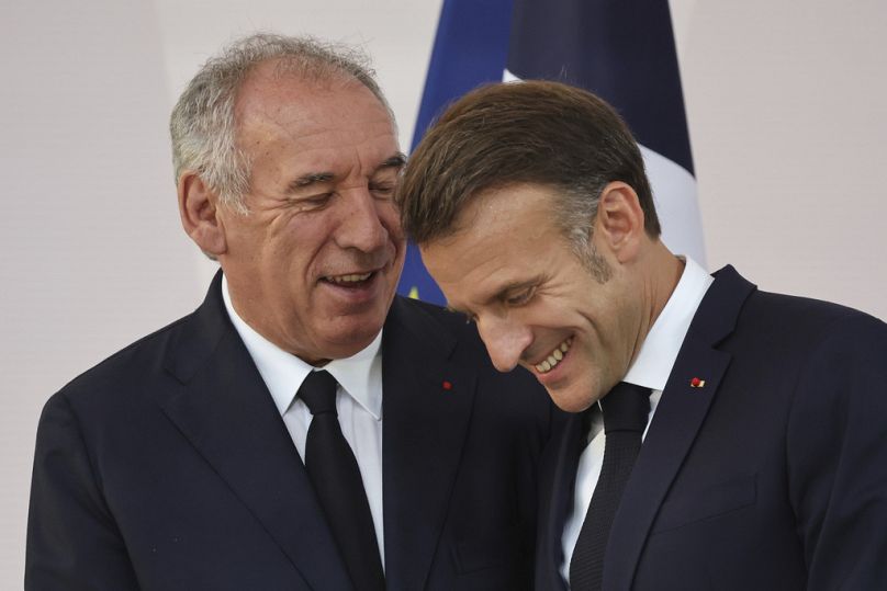 Le Premier ministre français François Bayrou, à gauche, et le président français Emmanuel Macron partagent un rire à la fin d'un discours du président aux chefs de l'armée.