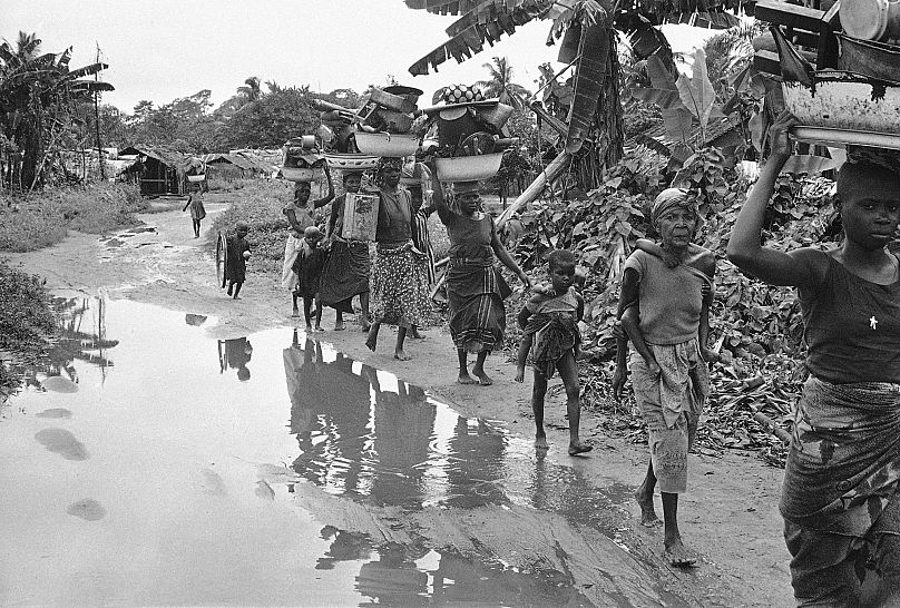 Ibo refugees from the breakaway Nigerian state of Biafra carry goods on their heads as they flee advancing Nigerian troops near Owerri, September, 1968