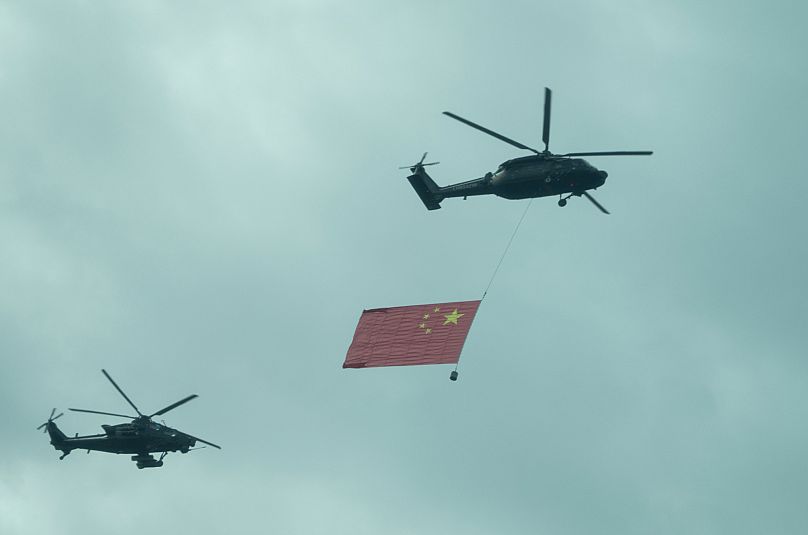 Chinese military helicopters fly over the central business district during a rehearsal ahead of the Sept. 3 military parade to commemorate the 80th anniversary of Japan's Worl