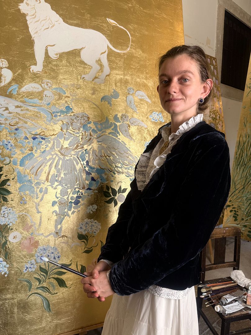 Veronika Blyzniuchenko junto a uma das suas pinturas