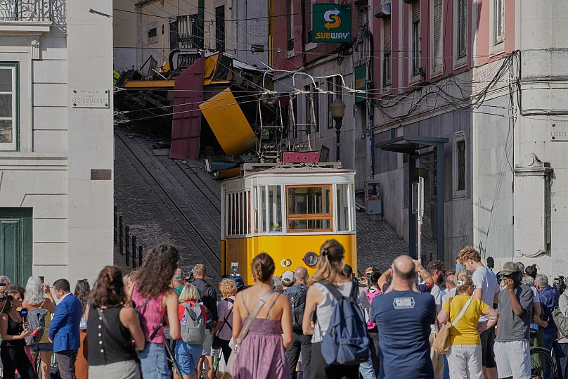 People look at a tourist streetcar that derailed and crashed in Lisbon, 4 September, 2025