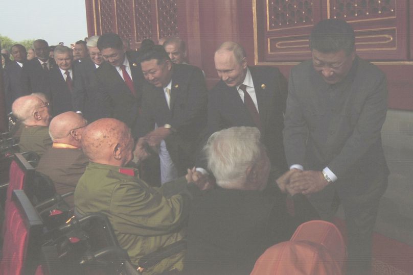 Xi Jinping, Vladimir Putin and Kim Jong-un are seen on a giant screen with other world leaders as they meet party elders ahead of a military parade in Beijing, Sept. 3, 2025