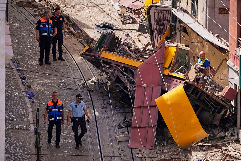 Police officers inspect the site where a tourist streetcar derailed and crashed in Lisbon, 4 September, 2025