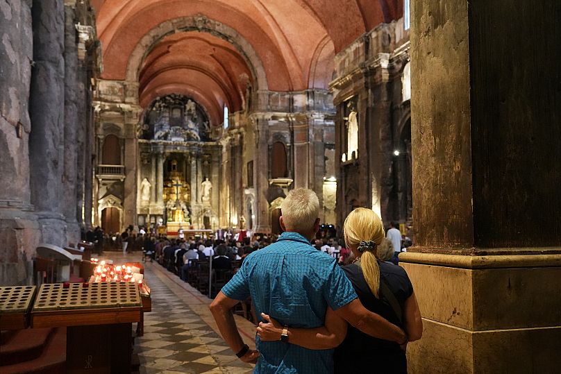 A couple attend a mass for the victims of a tourist streetcar that derailed and crashed in Lisbon, 4 September, 2025