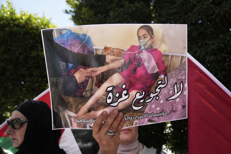 محتجون فلسطينيون يرفعون لافتات كُتب عليها "لا لتجويع غزة" خلال اعتصام أمام مكتب الأمم المتحدة في رام الله، 1 سبتمبر 2025.