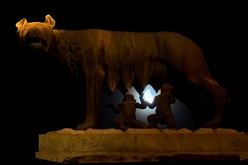 O eclipse lunar por detrás da estátua da loba a amamentar Rómulo e Remo, em Roma, na Itália.