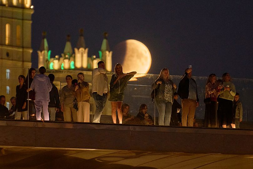 As pessoas admiram o eclipse lunar na ponte flutuante do Parque Sarjadje, em Moscovo.