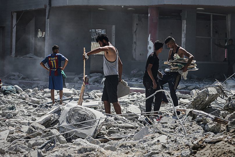 Palestinians inspect the damage after an Israeli army air strike on a high-rise building in Gaza City, 5 September, 2025