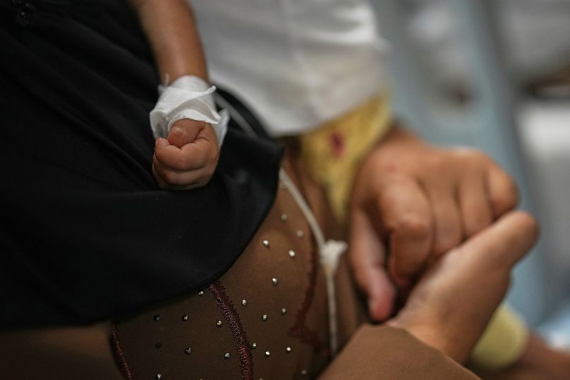 FILE: Islam Qudeih holds her daughter, Shamm, evacuated from Gaza during an interview with AP at a children's hospital in Naples, 2 September 2025