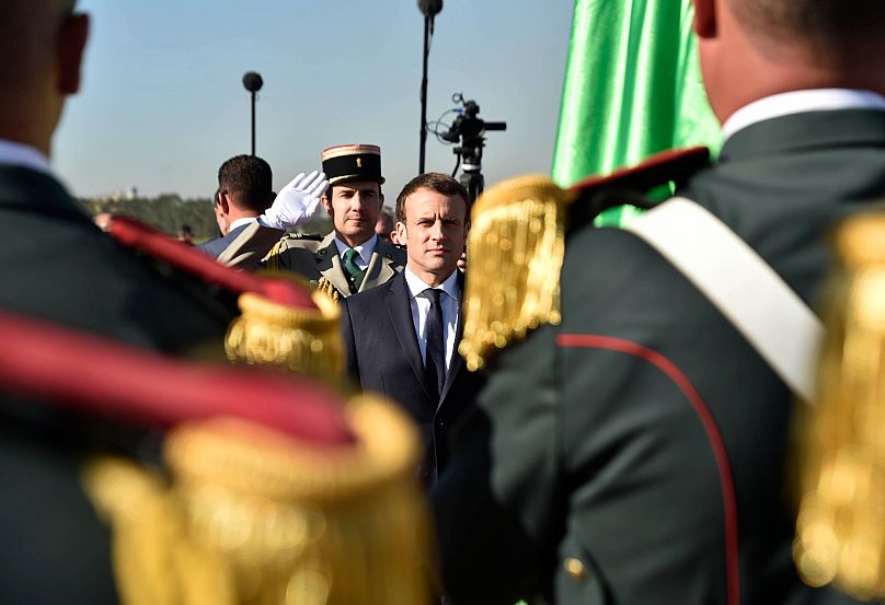 FILE: French President Emmanuel Macron reviews the troops as he arrives in Algiers, 6 December 2017