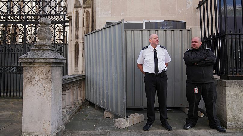 Security officials stand guard in front of barriers concealing Banksy's latest artwork in London, 8 September 2025