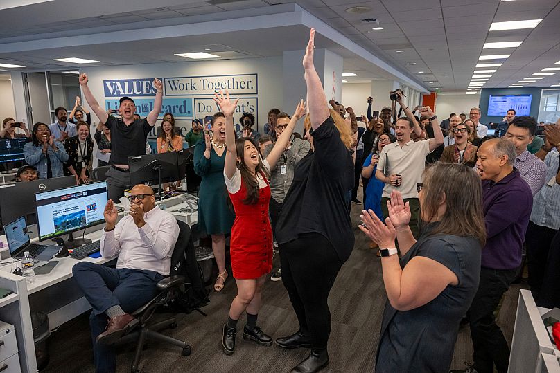 La reportera Alissa Zhu y la fotoperiodista Jessica Gallagher celebran con la redacción del Baltimore Banner tras ganar el Premio Pulitzer