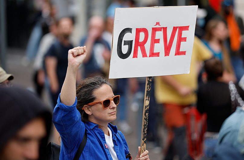 A protester holds a placard that reads "strike" during a rally of the "Block Everything" movement in Lille, 10 September, 2025