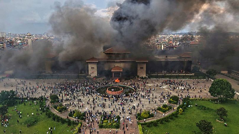 Protesters celebrate as government ministries and offices are set on fire during a protest in Kathmandu, 9 September, 2025