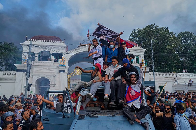 Protesters celebrate as government ministries and offices are set on fire during a protest in Kathmandu, 9 September, 2025