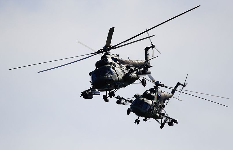 FILE: Two Belarusian military helicopters fly during military exercises, near the Volka village, 19 September 2017