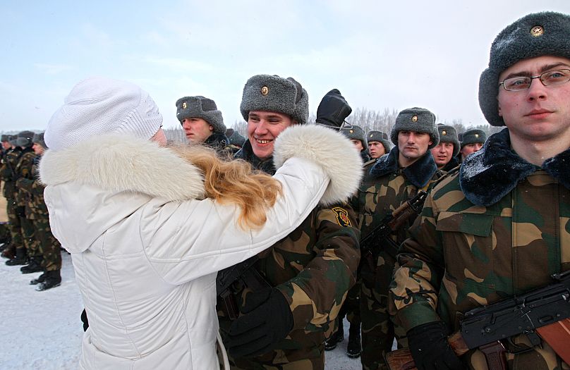 FILE: Belarus soldier meets with his relative after taking an oath ceremony in the town of Borisov, 12 February 2011