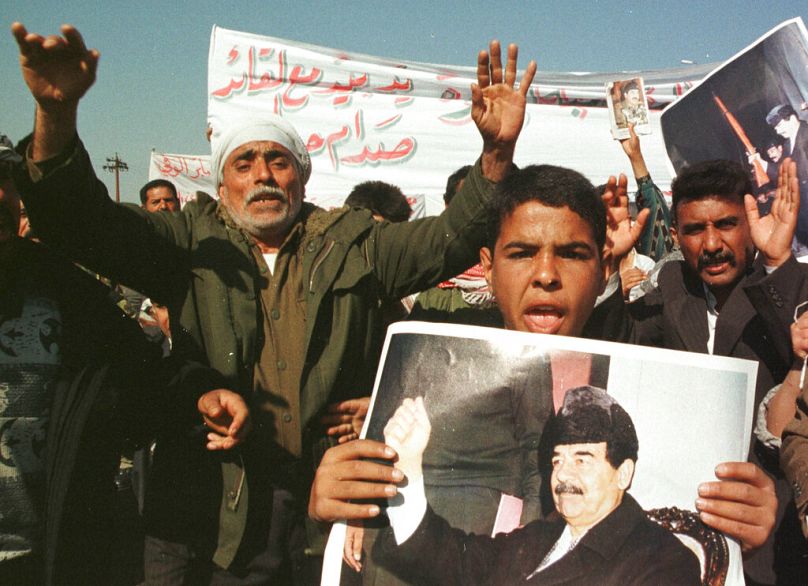 المتظاهرون يحملون صور الرئيس العراقي صدام حسين خلال مظاهرة مناهضة لأميركا في بغداد، يوم الخميس 25 فبراير 1999