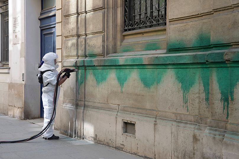 FILE: A worker cleans the defaced with green paint Synagogue des Tournelles after several Jewish sites across the capital were defaced with green paint, 31 May 2025