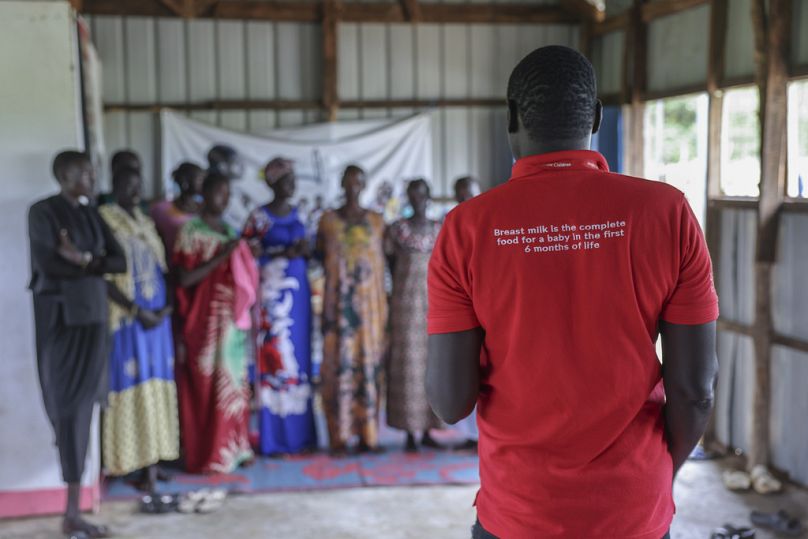 An aid worker speaks to mothers eligible for nutrition support in an camp for internally displaced people in Bor, South Sudan, Aug 18, 2025.
