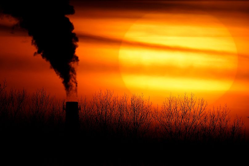 FILE - Emissions from a coal-fired power plant are silhouetted against the setting sun in Kansas City, Mo., Feb. 1, 2021. 