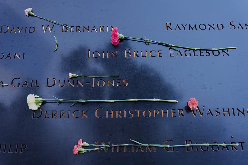 Flowers are placed on names inscribed at the 9/11 Memorial before the start of a ceremony commemorating the 24th anniversary of the tragedy.. 