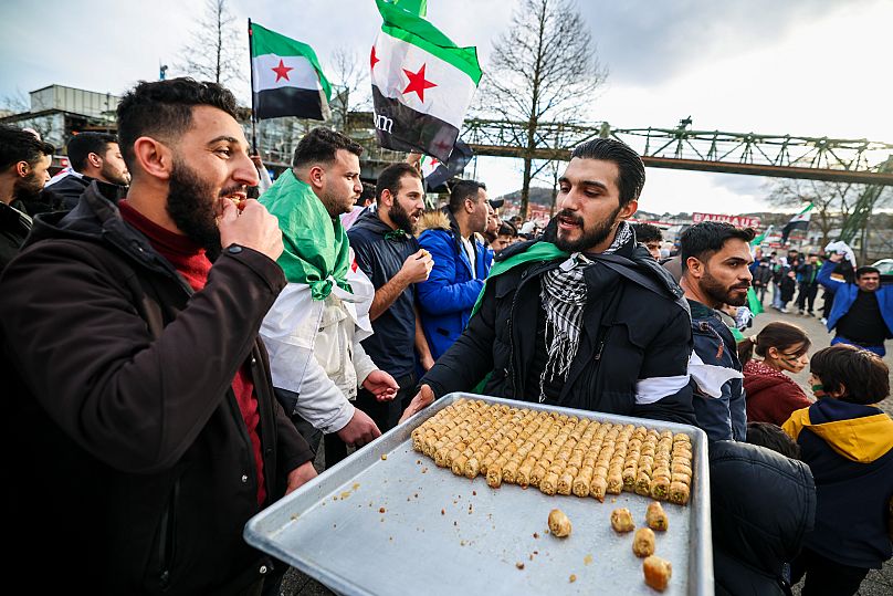 Des Syriens brandissent des drapeaux de l'opposition lors d'un rassemblement spontané à Wuppertal, en Allemagne, après la chute du gouvernement de Bachar al-Assad.