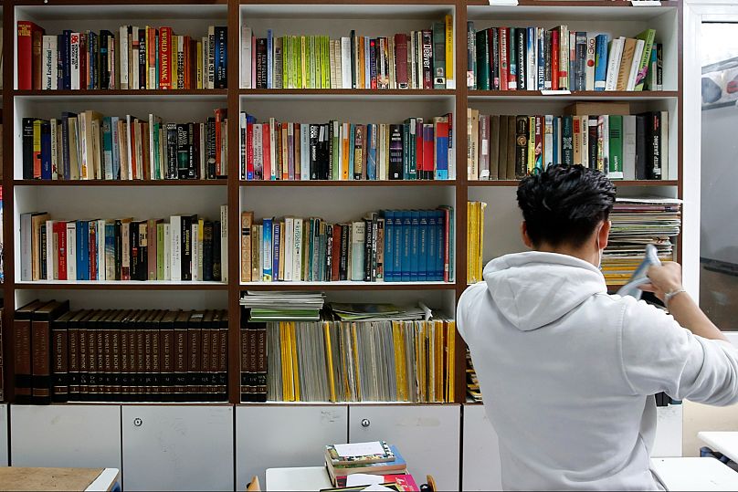 File: An inmate takes a book from a prison library