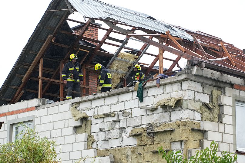 Firefighters gather on a destroyed roof to inspect a damaged house, after multiple Russian drones struck, in Wyryki near Lublin, Poland, 11 September 2025.