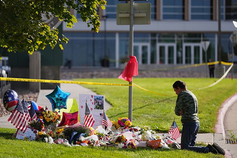 Wendy Lucas, a Utah Valley University student, kneels at a memorial set up for Charlie Kirk at Utah Valley University in Orem, Utah, Friday, 12 Sep, 2025.